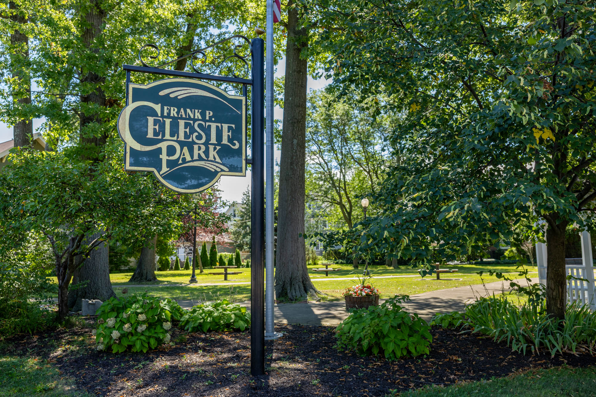 Celeste Park sign with trees and green space in background.