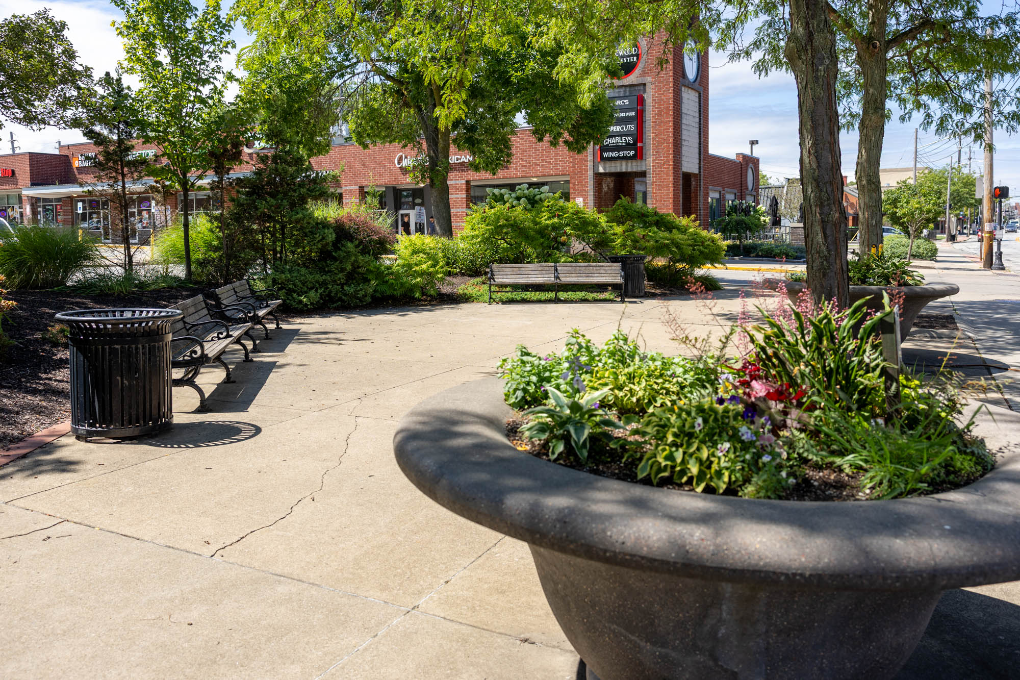 City Center Park with planters, benches, trees, and a sidewalk area.