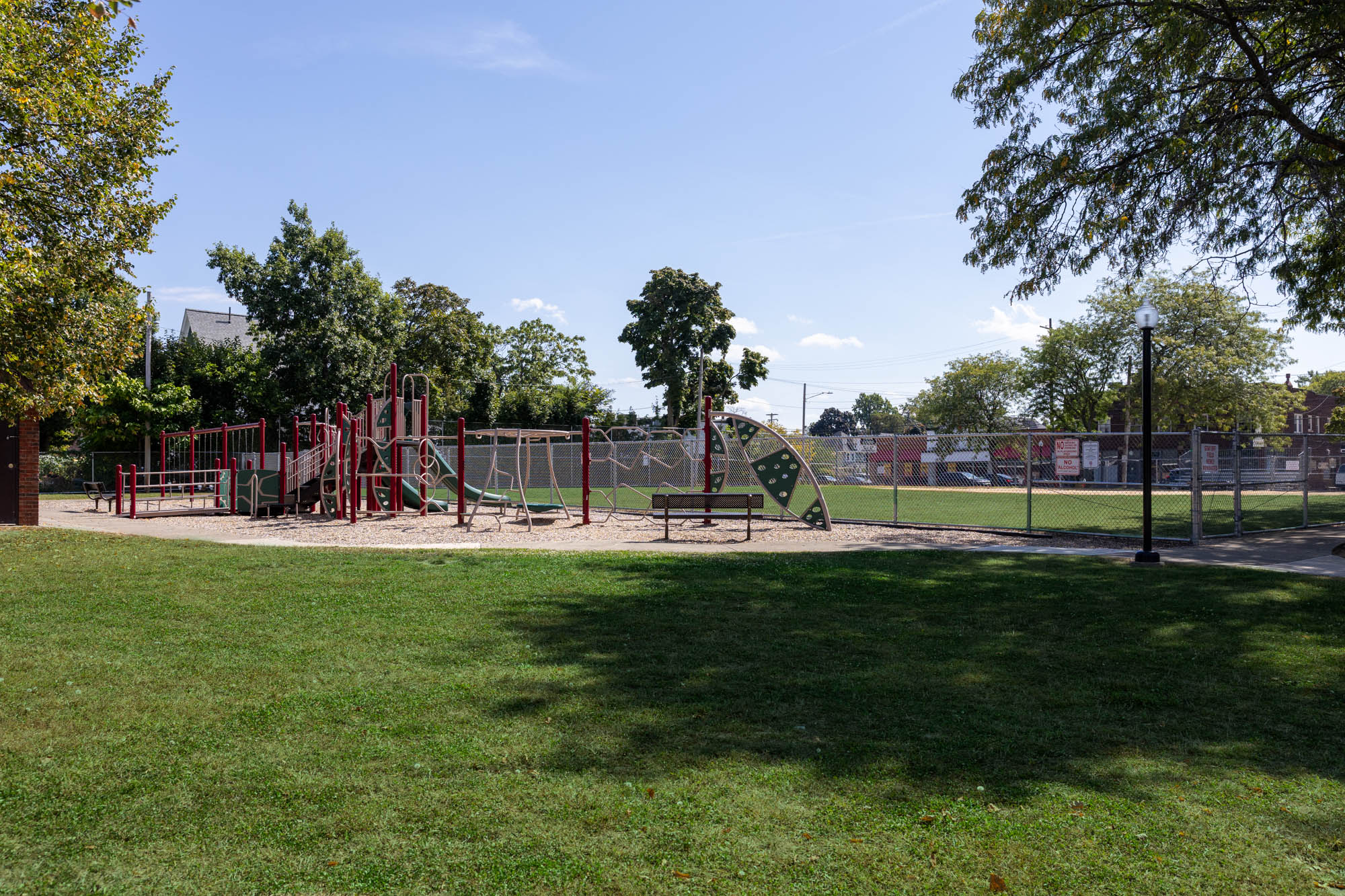 Edwards Park - Grass in foreground, playground and baseball field in background.
