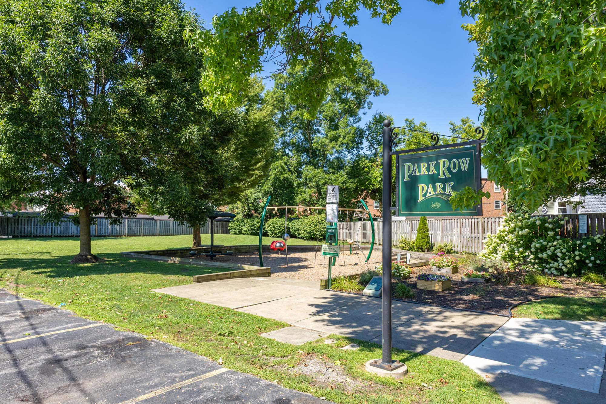Park Row Park: sign, playground, and green space area.