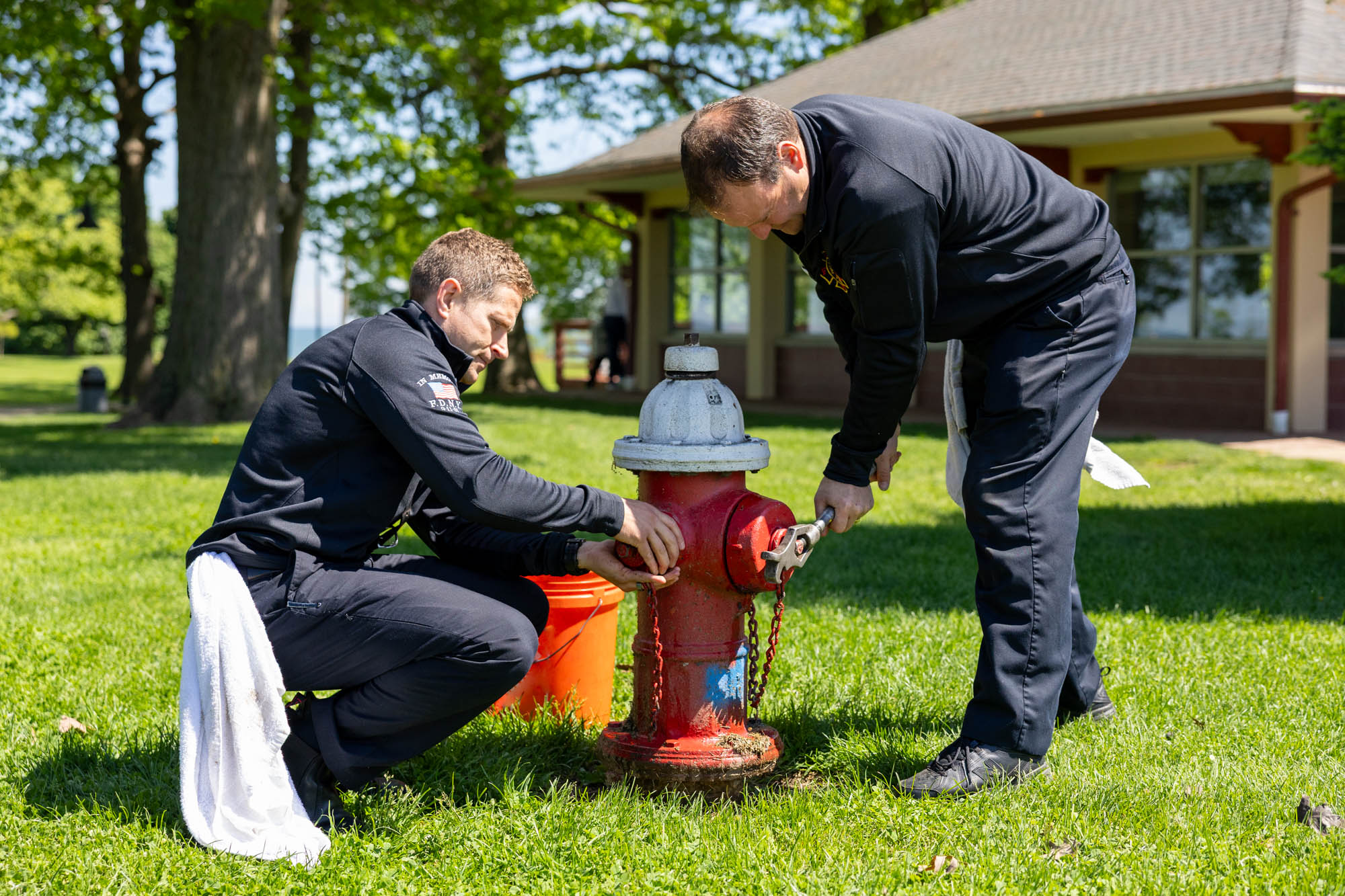 Two Lakewood firefighters test a fire hydrant at Lakewood Park.
