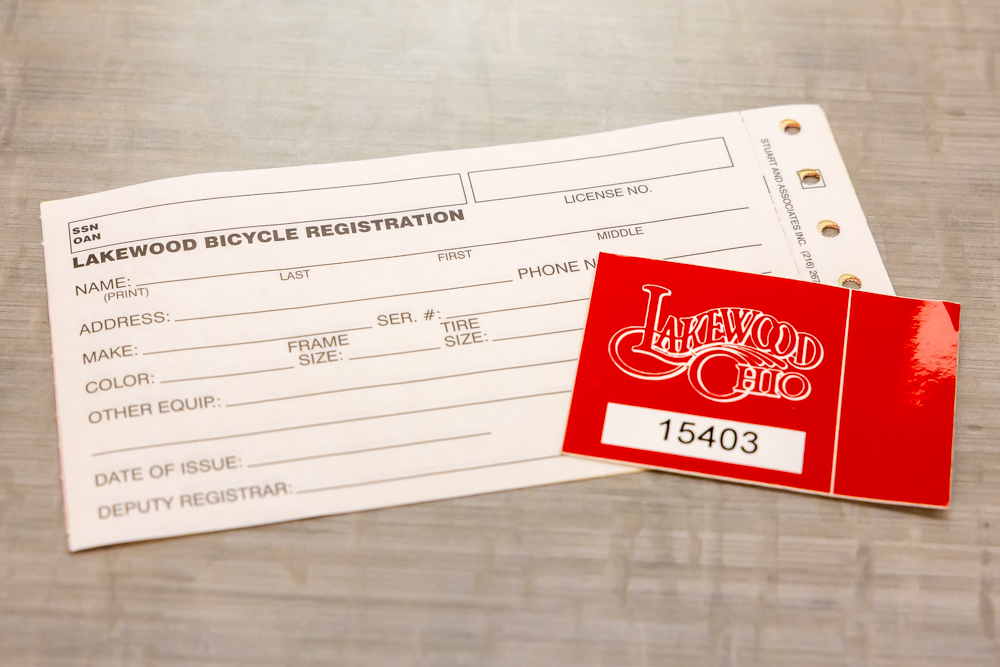 A blank paper bike license form and red license sticker.